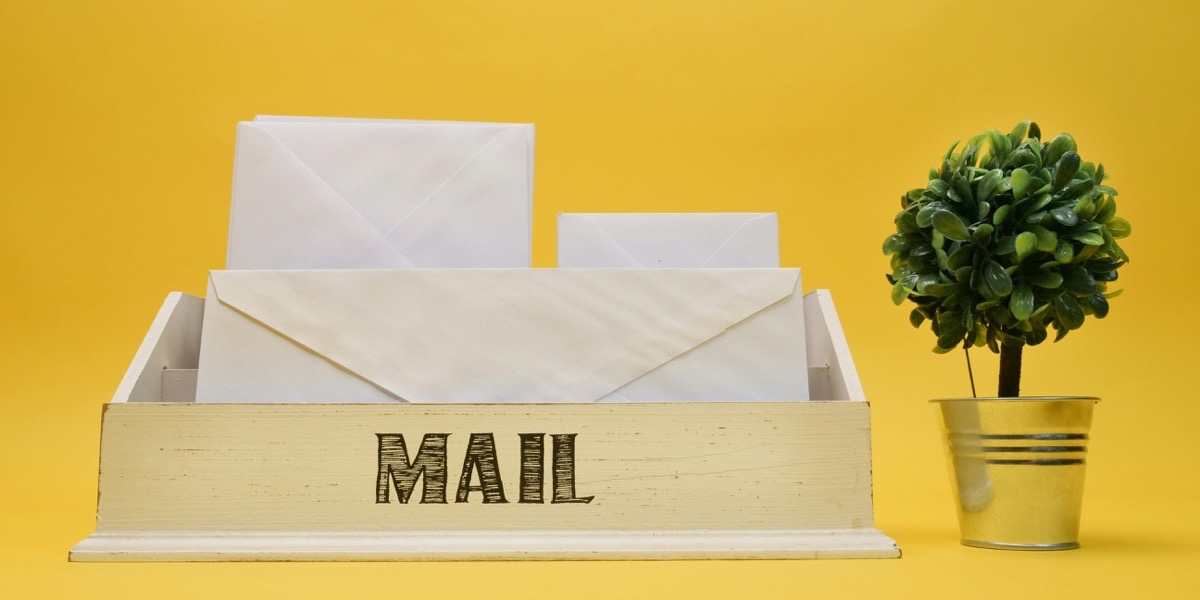Email marketing : boîte mail en bois avec des enveloppes blanches sur fond jaune